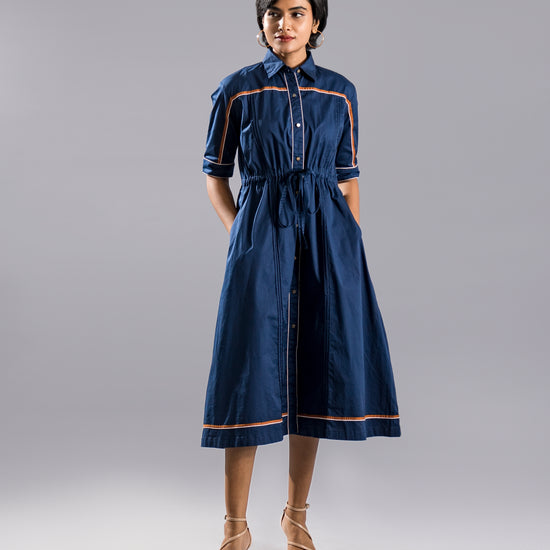 Model posing in a navy blue shirt dress