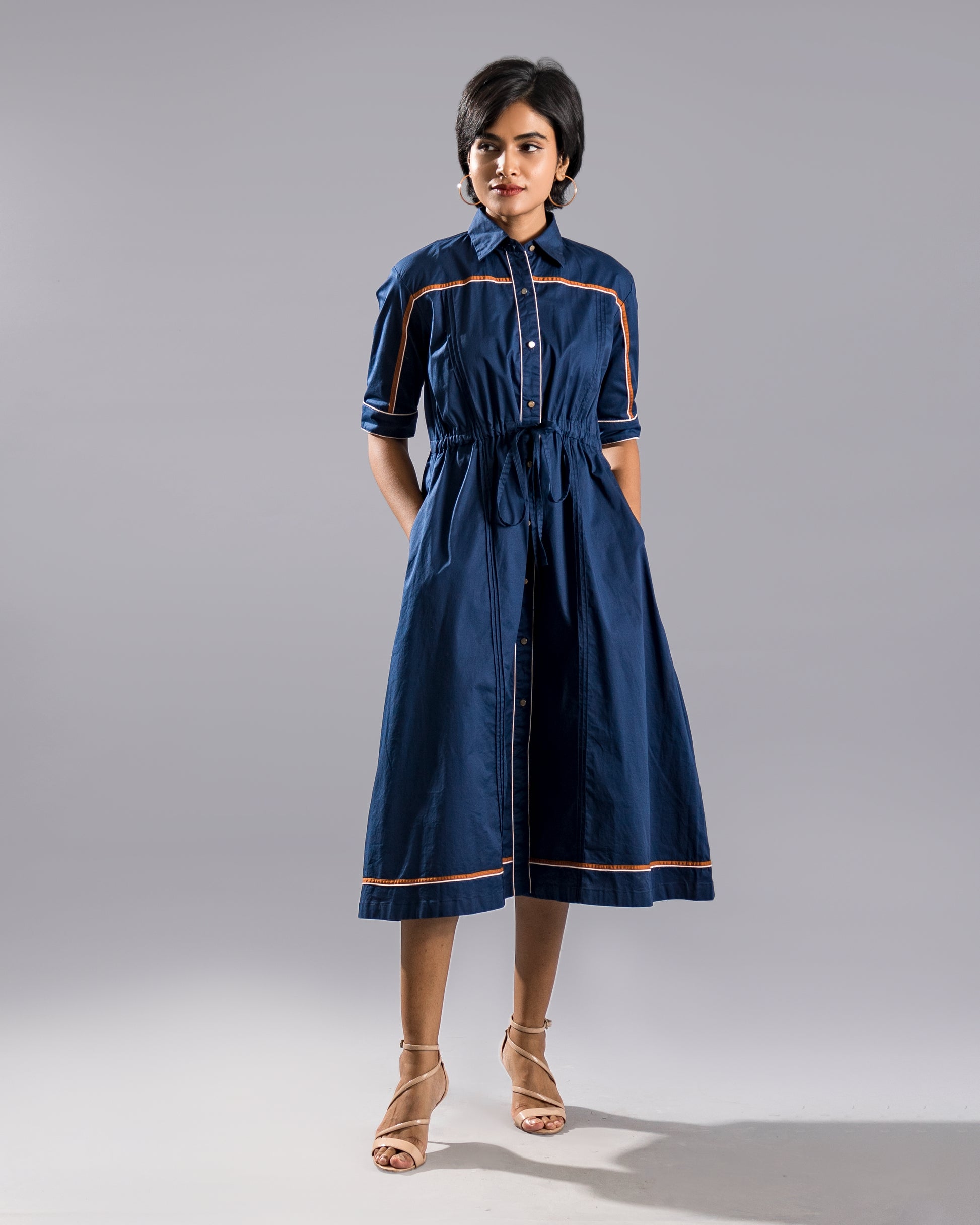 Model posing in a navy blue shirt dress